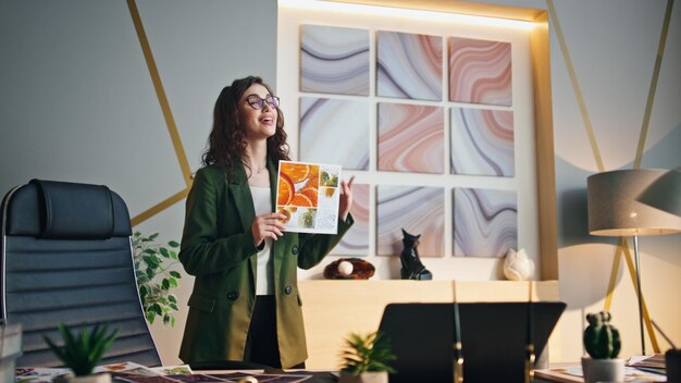 Mujer presentando una conferencia en línea de diseño en una oficina moderna.