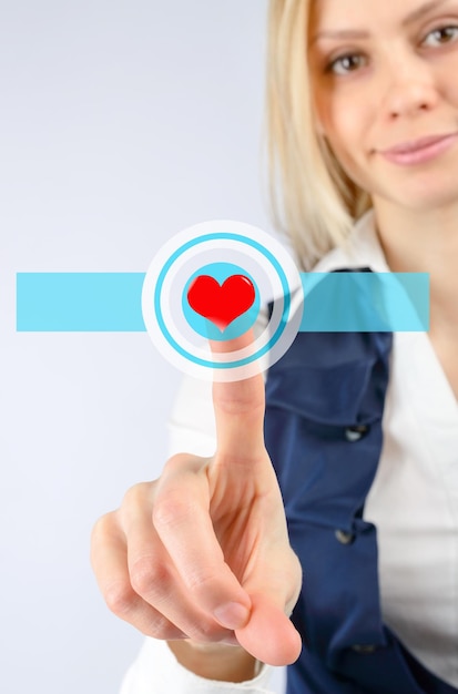 Foto la mujer presiona el icono del corazón táctil. sobre un fondo claro