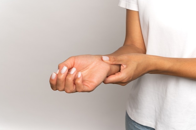 Foto mujer presionando los dedos en la muñeca comprobar el pulso femenino tocar el brazo medir los latidos del corazón o la presión arterial