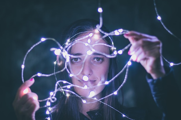 Mujer de primer plano con luces de hadas