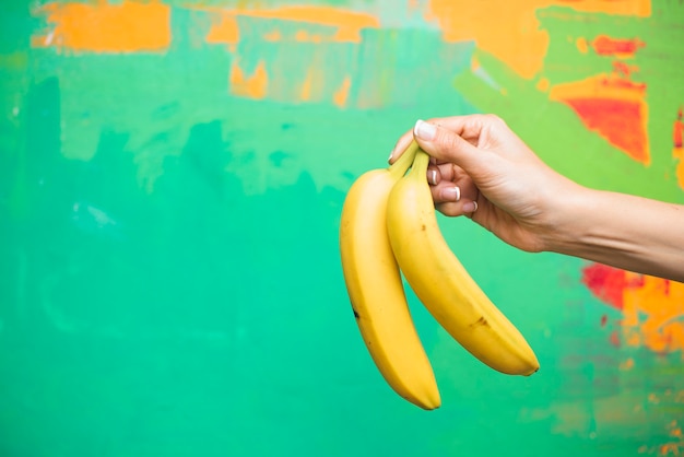 Foto mujer de primer plano con plátanos y colores de fondo