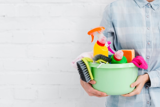 Mujer de primer plano con productos de limpieza