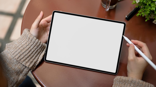 Foto mujer de primer plano en suéter de punto acogedor con maqueta de pantalla blanca de tableta táctil de tableta inteligente