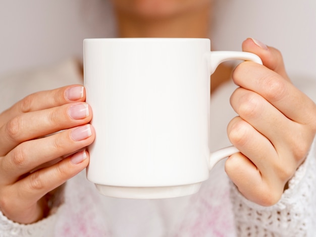 Mujer de primer plano con suéter y taza