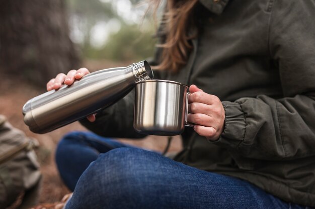 Foto mujer de primer plano con termo y taza