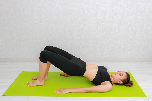 Mujer principiante haciendo yoga Mujer haciendo deporte en casa Posiciones de yoga y meditación