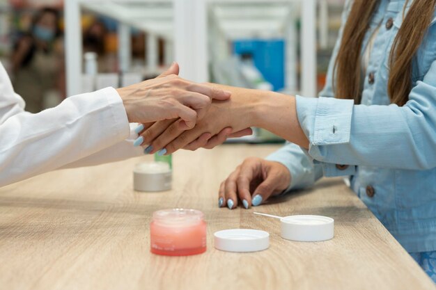 Una mujer probando una crema para la piel en una farmacia