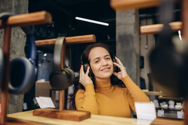 Mujer probándose auriculares en una tienda de acústica