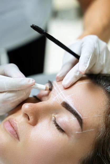 Mujer durante el procedimiento profesional de mapeo de cejas