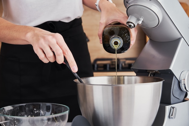 Mujer con procesador de alimentos para cocinar en la cocina