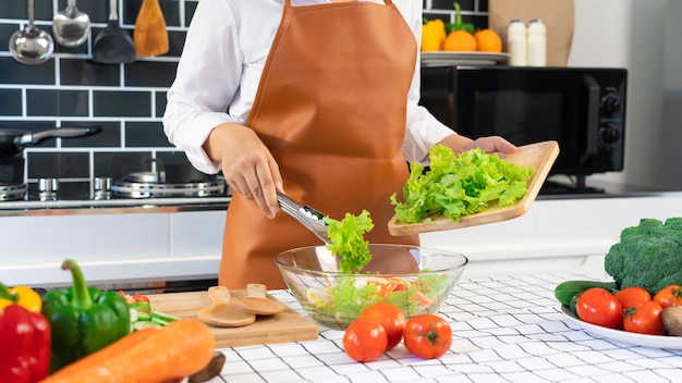 Mujer en el proceso de preparación de alimentos saludables Ensalada de verduras