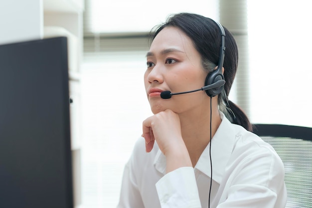 Mujer profesional con auriculares involucrada en una conversación en un espacio de trabajo de oficina moderno