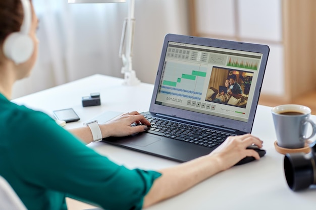 mujer con programa de editor de video en la computadora portátil en casa