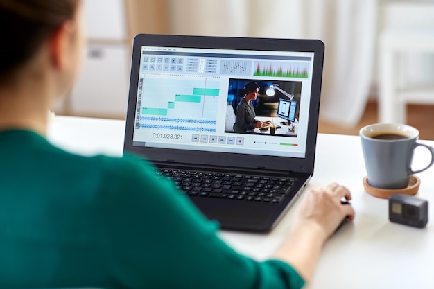 mujer con programa de editor de video en la computadora portátil en casa
