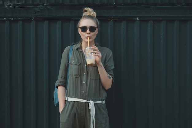 Mujer progresista, con gafas de sol con un vaso de refrescante