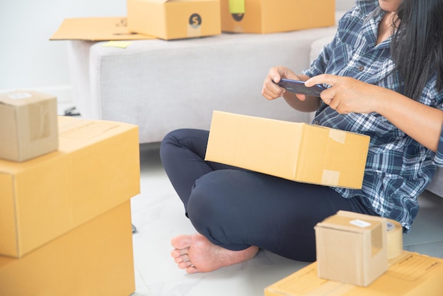 Mujer propietaria de una pequeña empresa que usa una aplicación móvil en un teléfono inteligente