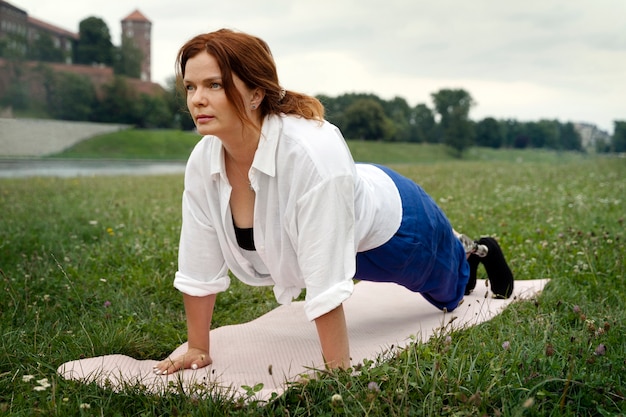 Mujer con prótesis de pierna haciendo yoga