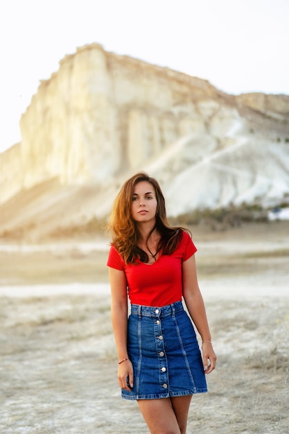 Mujer en la puesta de sol sobre el fondo de una roca blanca