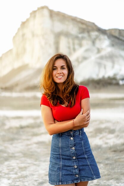 Mujer en la puesta de sol sobre el fondo de una roca blanca