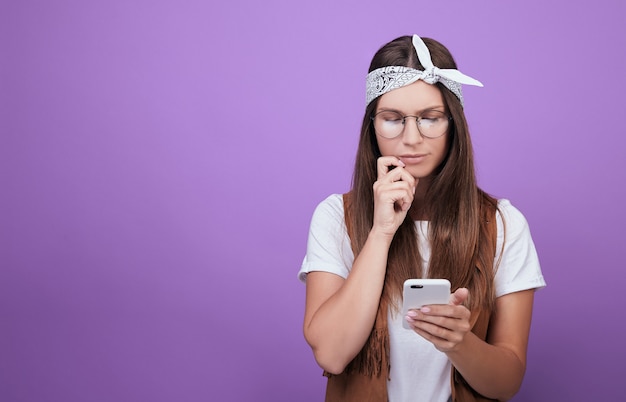 Una mujer en púrpura mira el teléfono.