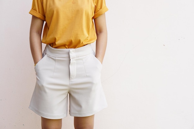 la mujer se puso las manos en los bolsillos y se puso ropa de buena apariencia aislada sobre un fondo de color gris