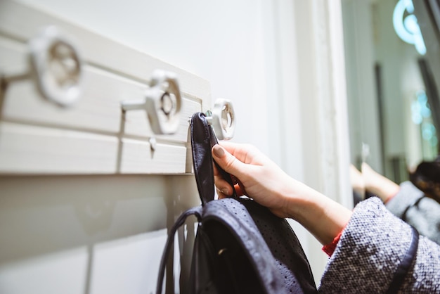 Mujer puso mochila en elegante colgador de pared