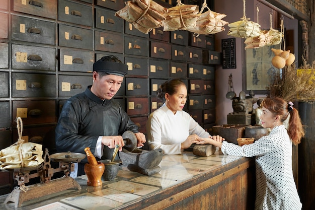 Mujer que asiste a una antigua farmacia china