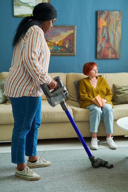 Mujer que ayuda a la anciana en las tareas del hogar