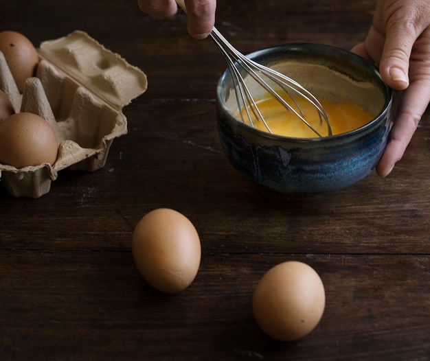 Mujer que bate la idea de la receta de la fotografía de la comida de los huevos