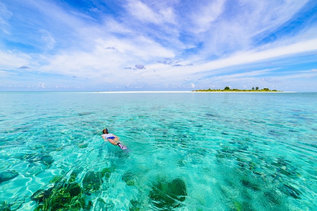 Mujer que bucea en el mar del Caribe tropical del arrecife de coral, agua de azules turquesa. Indonesia archipiélago de Wakatobi, parque nacional marino, destino de viaje de buceo turístico