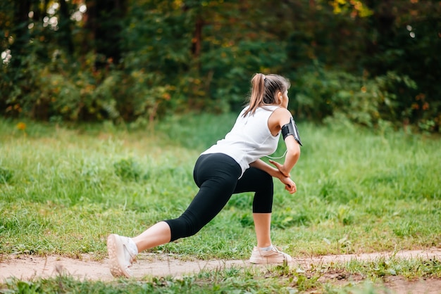 Mujer que corre en el bosque de la caída del otoño. Estilo de vida saludable . Ajuste el modelo de fitness étnico caucásico.