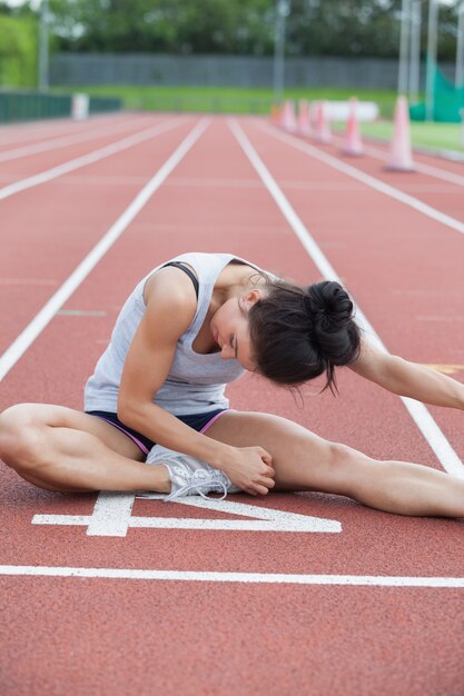 Mujer que se extiende en una pista