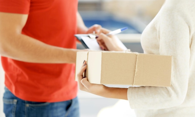 Foto mujer que firma el recibo del paquete de entrega de cerca