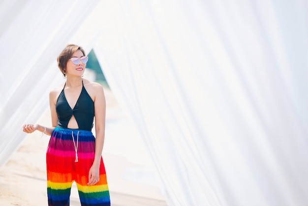 Mujer que goza de la playa que relaja alegre en verano por el agua azul tropical.