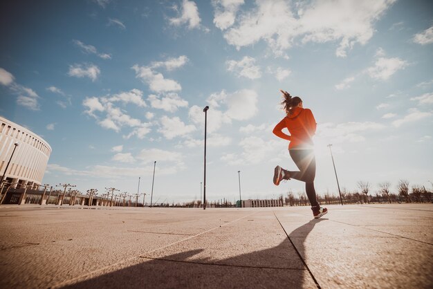 Una mujer que hace jogging corre por las calles.