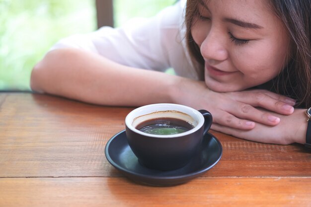 mujer que huele y bebe café