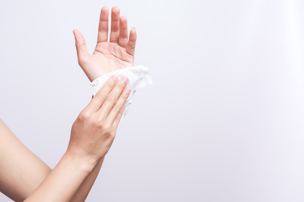 Mujer que limpia sus manos con el papel de tejido suave blanco. aislado en un fondos blancos