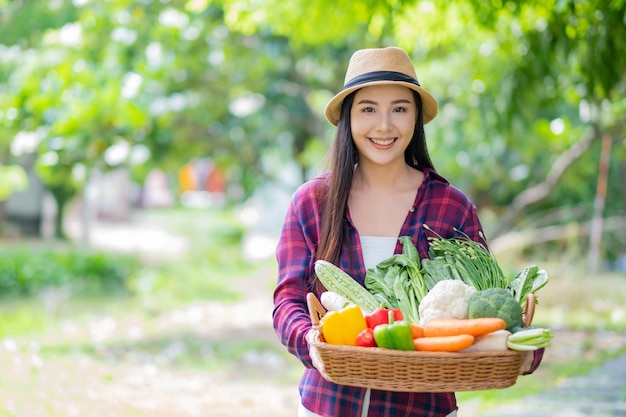 Mujer que llevaba la cesta de verduras con fondo desenfocado