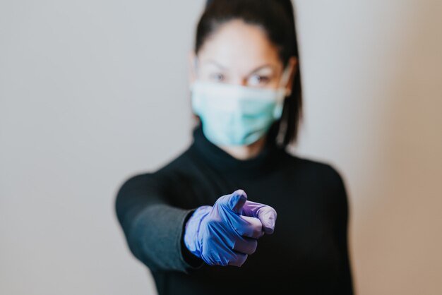 mujer que llevaba una máscara de protección apuntando con el dedo