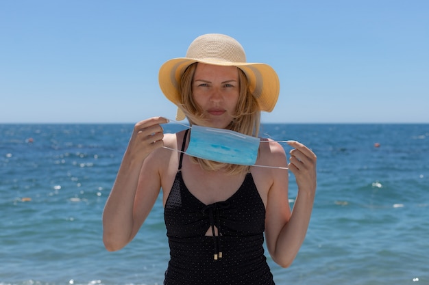 Mujer que llevaba una mascarilla en la playa