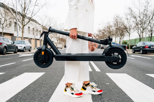 Foto una mujer que llevaba un scooter eléctrico plegable