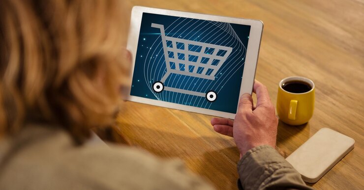 Foto mujer que mira el icono del carro de compras en la pc de la tableta