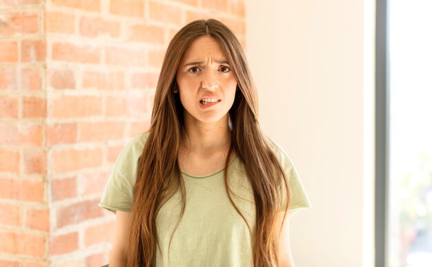 mujer que parece perpleja y confundida, mordiéndose el labio con un gesto nervioso, sin saber la respuesta al problema