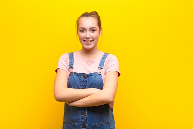 Mujer que parece un triunfador feliz, orgulloso y satisfecho sonriendo con los brazos cruzados