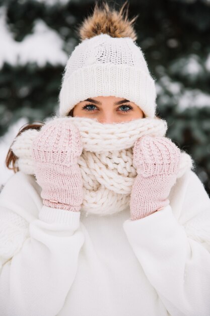 Mujer que presenta en parque con las luces de la Navidad. Concepto de vacaciones de invierno.