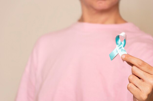 Mujer que promueve la concientización sobre el cáncer de mama con cinta rosa y azul para hombres y mujeres
