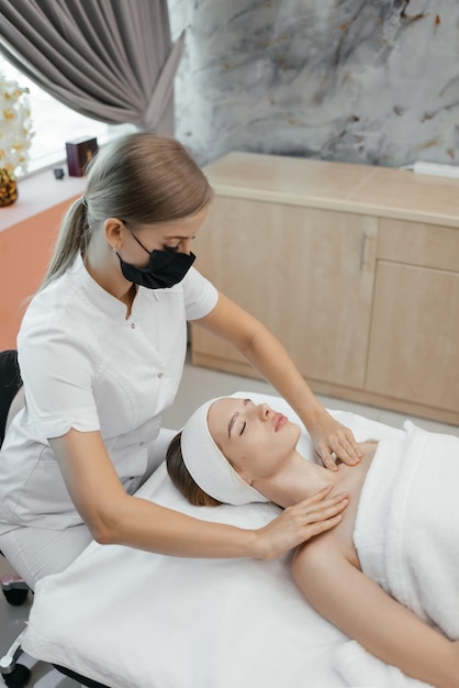 Una mujer que recibe un masaje facial en un salón de spa