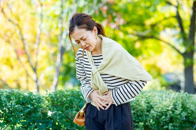 Mujer que siente dolor abdominal al aire libre