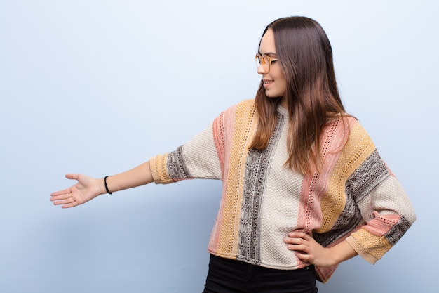 Foto mujer que se siente feliz y alegre, sonriendo y dándole la bienvenida, invitándote a entrar con un gesto amistoso