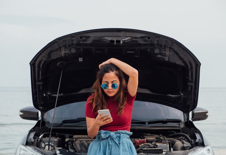 Una mujer que se siente mal durante su viaje porque su automóvil tiene algo roto.